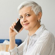 Woman with silver hair talking on a cell phone